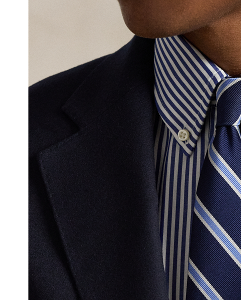 An essential building block of the  Ralph Lauren Lauren look, our iconic Polo blazer is the result of time-honoured traditions spanning decades of impeccable design. Its doeskin wool was custom-developed in collaboration with Italian weavers to achieve a finer, softer, and lighter feel than anything before and finished to reduce shine. The soft shoulder, which harkens to classic American haberdashery, is achieved through meticulous interior tailoring that trims excess fabric and padding, followed by a unique pressing process. Fine canvassing combined with an elegant lapel roll and a lower button stance creates an ideal silhouette that can be worn both formally and casually.