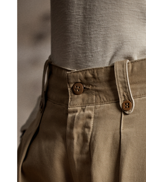 Inspired by 1940s trousers. Made from Japanese piece-dyed cotton twill. Hand-set back flapped pockets. Stitched-down pleated front. Buttoned belt loops and adjustable tabs on the sides. Stonewashed.