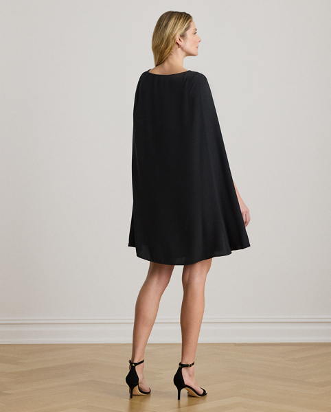 A stylish choice for special occasions, this modern georgette cocktail dress is elevated by a cascading cape, which adds fluid movement to its body-hugging silhouette.