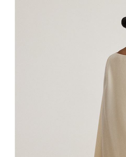 A stylish choice for special occasions, this modern georgette cocktail dress is elevated by a cascading cape, which adds fluid movement to its body-hugging silhouette.