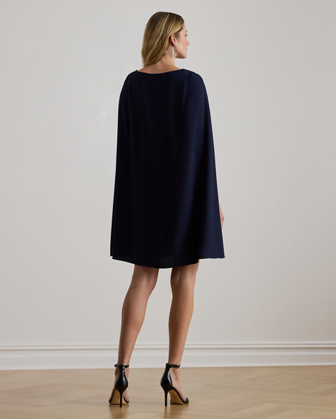 A stylish choice for special occasions, this modern georgette cocktail dress is elevated by a cascading cape, which adds fluid movement to its body-hugging silhouette.
