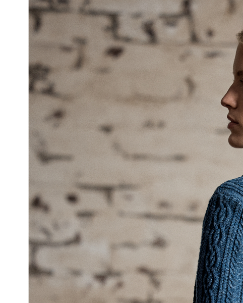 Cable-knit cardigan made with cotton and semi-worsted wool. Designed with a shawl collar and accented with waist patch pockets. Finished with genuine horn buttons.