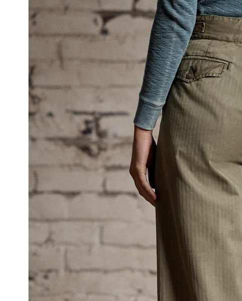 Cropped wide-leg trouser inspired by 1940s trousers. Made with Japanese piece-dyed cotton twill. Features hand-set back flapped pockets and a stitched-down pleated front. Buttoned belt loops and adjustable tabs on the sides. Stonewashed.