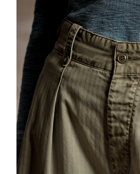 Cropped wide-leg trouser inspired by 1940s trousers. Made with Japanese piece-dyed cotton twill. Features hand-set back flapped pockets and a stitched-down pleated front. Buttoned belt loops and adjustable tabs on the sides. Stonewashed.