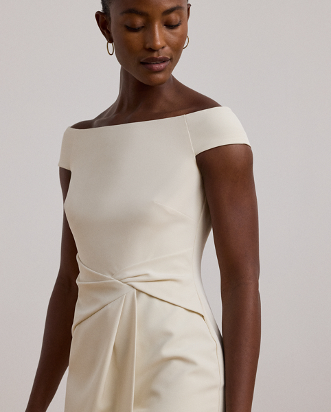 Crafted with smooth crepe for a fluid drape and a luxurious sensibility, this cocktail dress is designed with an elegant off-the-shoulder silhouette and a chic twist detail on the waist. A slit in the skirt creates ease of movement.