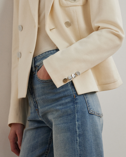 Crafted with a soft, stretch-infused cotton jacquard fabric, this sophisticated blazer is defined by a double-breasted silhouette and peak lapels. A bullion patch at the chest adds signature style, while waist darts and panel seams afford a tailored finish.