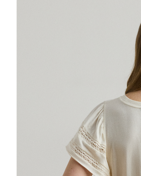 Crafted from soft jersey, this feminine crewneck top features flutter sleeves detailed with delicate lace insets.