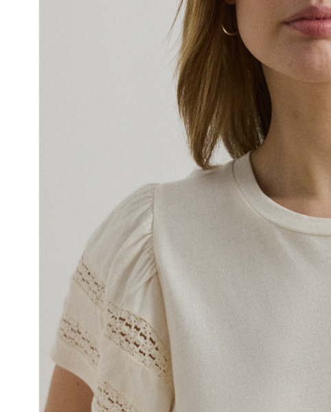 Crafted from soft jersey, this feminine crewneck top features flutter sleeves detailed with delicate lace insets.