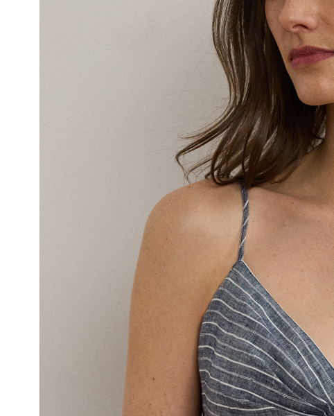 Crafted with lightweight linen, this sleeveless dress features a fit-and-flare silhouette complemented by a belted waist, slender yarn-dyed stripes and a twist-front bust.