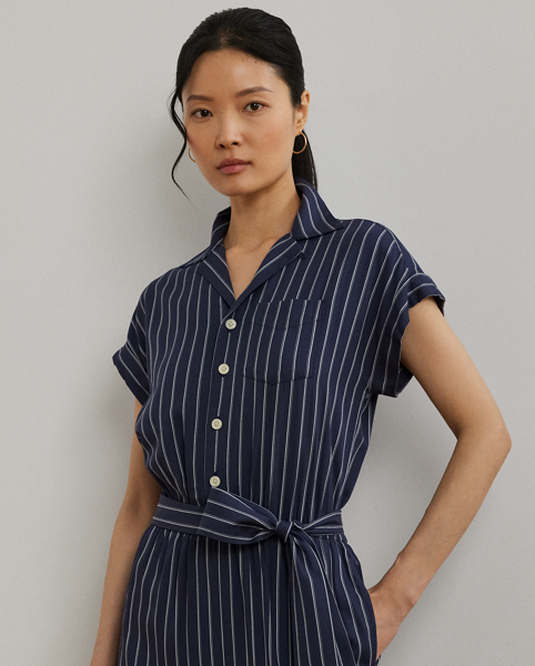 With its wide-leg silhouette, yarn-dyed striped twill fabrication and rolled cuffs, this camp collar jumpsuit exudes easy sophistication. A coordinating self-belt accentuates the waist and completes the look.