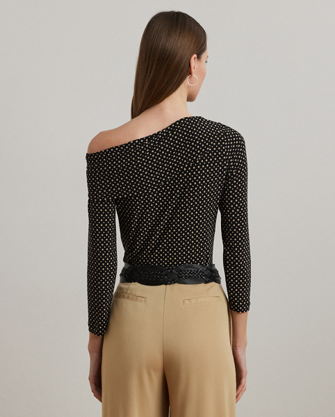 A twist-front accent beautifully complements the asymmetrical off-the-shoulder neckline of this top, which is crafted with stretch jersey for a comfortable feel. This version displays the season's two-tone geometric print.