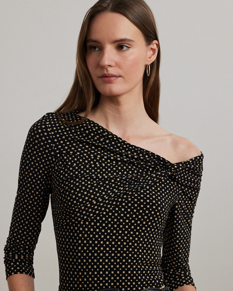 A twist-front accent beautifully complements the asymmetrical off-the-shoulder neckline of this top, which is crafted with stretch jersey for a comfortable feel. This version displays the season's two-tone geometric print.
