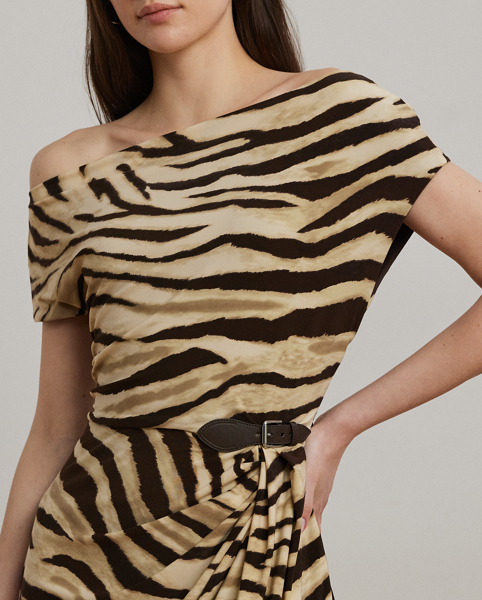 Blending timeless elegance with modern design elements, this off-the-shoulder dress with asymmetrical sleeves is beautifully draped to create a pleated, sheath silhouette. Punctuated by a faux-leather buckled tab at the waist, this style is crafted with soft jersey showcasing the season's zebra print.