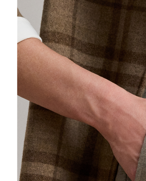 Crisp creases and pleats enhance the wide-leg silhouette of these trousers, which are crafted from wool herringbone twill for subtle texture and a refined sensibility. Displaying a subtle checked pattern, this style is finished with signature horn-effect buttons, waist darts and folded cuffs.