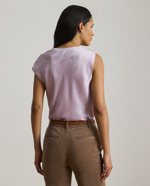 Beautifully draped in glossy satin charmeuse, this blouse features an asymmetrical design with one cap sleeve and a twisted strap. A keyhole detail and pleats at the strap complete the look.