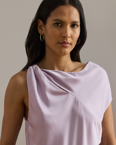 Beautifully draped in glossy satin charmeuse, this blouse features an asymmetrical design with one cap sleeve and a twisted strap. A keyhole detail and pleats at the strap complete the look.