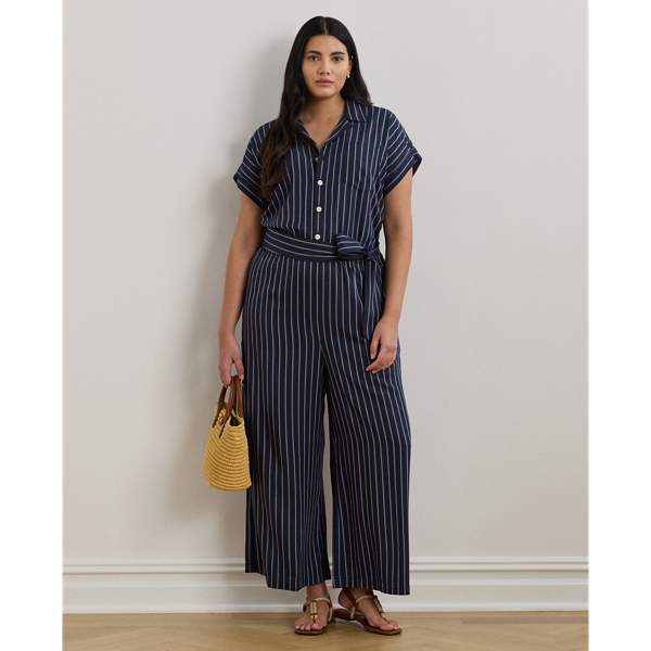 With its wide-leg silhouette, yarn-dyed striped twill fabrication and rolled cuffs, this camp collar jumpsuit exudes easy sophistication. A coordinating self-belt accentuates the waist and completes the look.