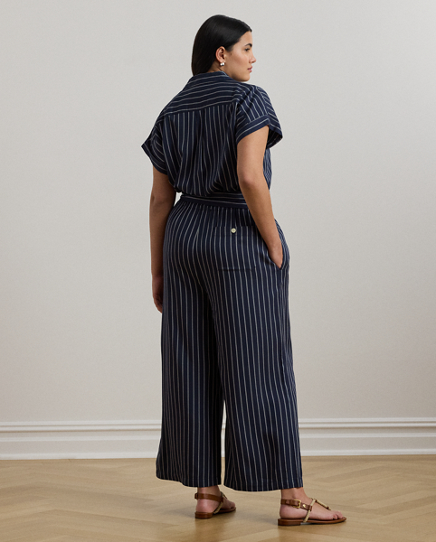 With its wide-leg silhouette, yarn-dyed striped twill fabrication and rolled cuffs, this camp collar jumpsuit exudes easy sophistication. A coordinating self-belt accentuates the waist and completes the look.