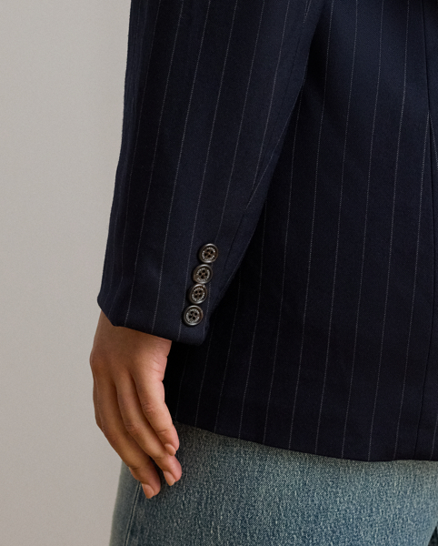 Slender, yarn-dyed pinstripes punctuate the structured silhouette of this sophisticated double-breasted blazer, which is finished with peak lapels and signature horn-effect buttons.