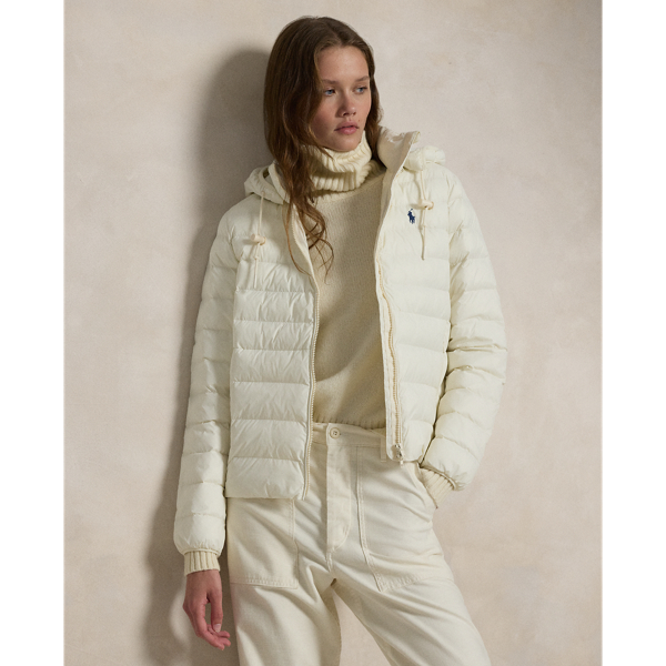 Made with water-repellent fabric, this quilted jacket features an insulating fill and a removable drawstring hood. It packs into its own pocket for easy storage and transport.