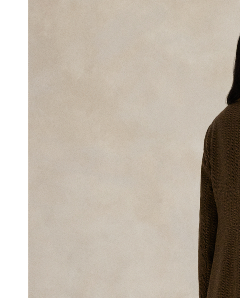 Tailored in Portugal, this coat showcases refined herringbone tweed and minimalist design elements – from its single-button closure and clean-lined silhouette to its classic peak lapels.