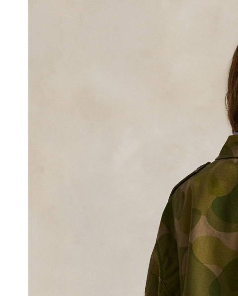 Printed for a surplus-inspired motif, this cotton field jacket balances a cropped silhouette with traditional details, including a buttoned storm placket over a concealed zip closure, shoulder epaulets and patch pockets. The authentic bi-swing construction features a drawstring waist and raw hem.
