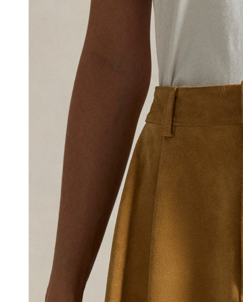 Cut for a high-rise, A-line silhouette that hits higher on the thigh, this sueded leather skirt features details reminiscent of tailored trousers, including a pleated construction and back waist welt pockets.