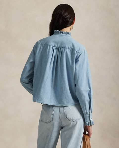 Made with medium-weight Japanese cotton chambray, this shirt is detailed with eyelet-embroidered ruffled trim and pintucking.