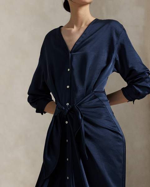Rendered in soft-falling, lightweight satin, this elegant piece merges classic shirtdress details, like a buttoned placket and pleated back yoke, with a V-neckline and tie-front wrap detail at the waist.