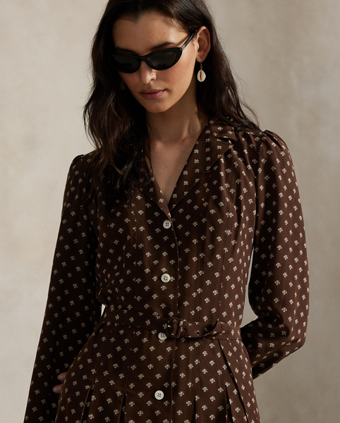 Accented by classic elements like notch lapels and a buttoned placket, this printed dress is crafted with silk crepe for a fluid drape and features a playful silhouette that combines subtle box-pleating and a belted waist.