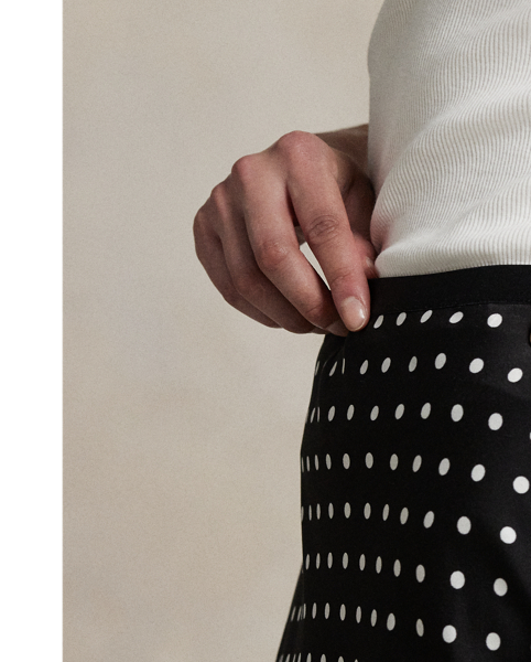 Printed with an all-over polka-dot motif, this satin skirt is cut on the bias for a slightly flared hem, bringing fluid movement to each step.