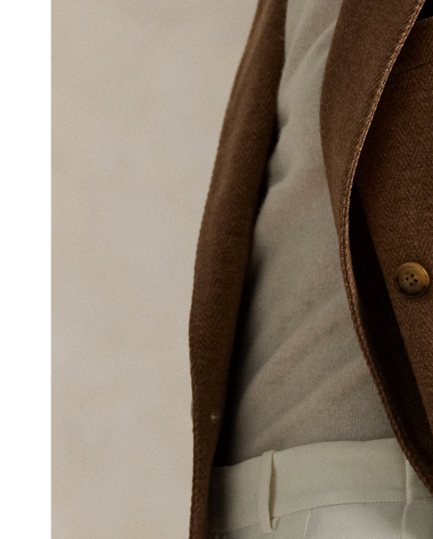 This double-breasted blazer is crafted with medium-weight wool-and-cotton fabric featuring a timeless herringbone weave and a lambskin suede undercollar.