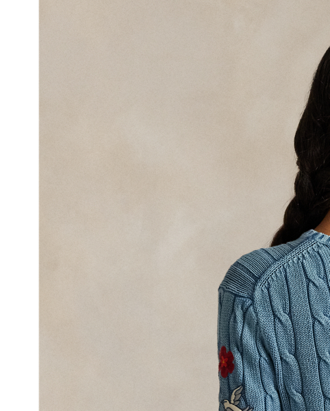 Treated for a high-low effect, this version of our cotton cable-knit jumper features an embroidered motif at the sleeve that unites colourful florals, a dove and  Ralph Lauren Lauren's monogram logo.