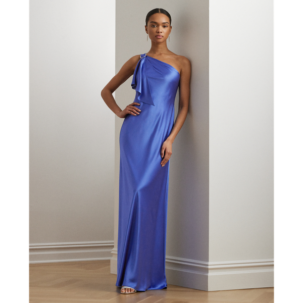 Hammered satin charmeuse gives a beautiful sheen and fluid drape to this one-shoulder gown, which features a delicately draped ruffle that cascades from a buckle at the shoulder.