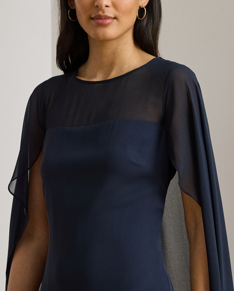 Turn heads at your next event in this glamorous georgette gown, which is designed with a floor-length, semi-sheer cape overlay and a statuesque column silhouette.