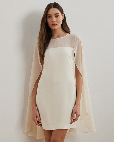 Turn heads at your next event in this glamorous cocktail dress, which is designed with a cascading, semi-sheer cape overlay and a figure-defining sheath silhouette.