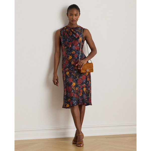 Satin charmeuse brings a beautiful sheen and graceful drape to this sleeveless cocktail dress, which depicts the season's painterly florals against a navy backdrop. Pleats on the shoulder provide an elegant finish.