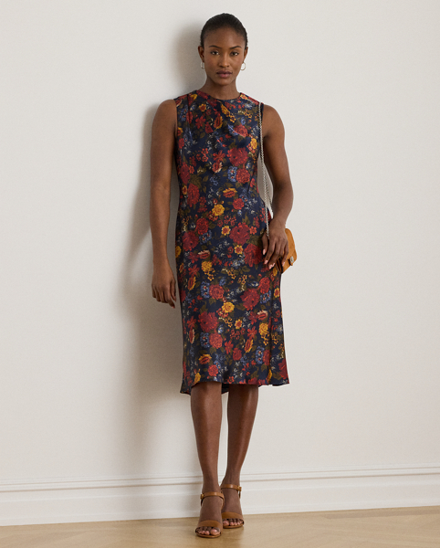 Satin charmeuse brings a beautiful sheen and graceful drape to this sleeveless cocktail dress, which depicts the season's painterly florals against a navy backdrop. Pleats on the shoulder provide an elegant finish.