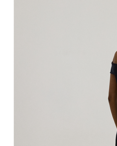 Evoking timeless glamour, this off-the-shoulder gown is designed with thoughtfully placed vertical seams, which accentuate its statuesque column silhouette. A slit on the skirt and smooth, stretch-infused crepe afford ease of movement.