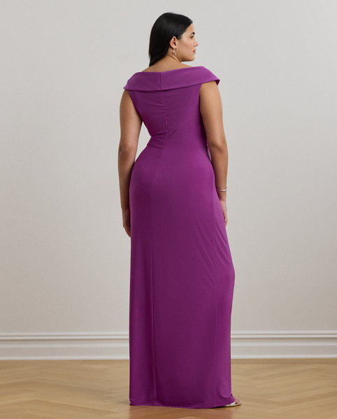 Crafted from smooth, body-hugging jersey, this column gown is designed with an elegant off-the-shoulder silhouette and a chic twist detail on the waist. A slit in the skirt creates ease of movement.