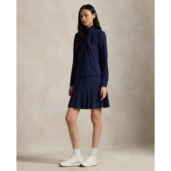 Constructed for an A-line silhouette, this stretch interlock skirt moves with you and features laser-cut eyelet panels. It's outfitted with an interior short with ball pockets.