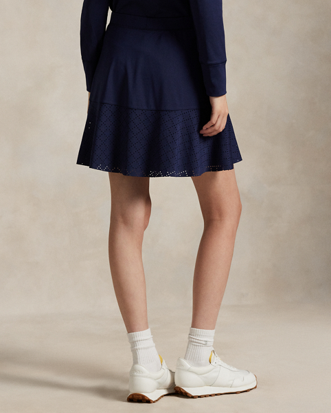 Constructed for an A-line silhouette, this stretch interlock skirt moves with you and features laser-cut eyelet panels. It's outfitted with an interior short with ball pockets.