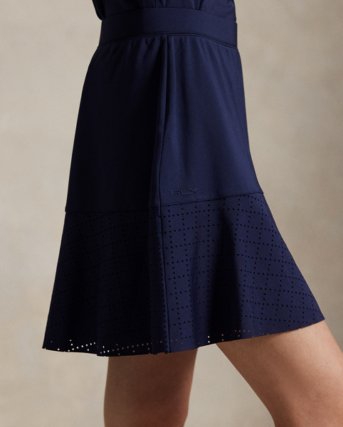 Constructed for an A-line silhouette, this stretch interlock skirt moves with you and features laser-cut eyelet panels. It's outfitted with an interior short with ball pockets.