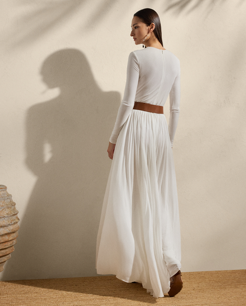 Beautifully understated, this sweeping day dress is crafted with crepe jersey for a flattering fit and a lightweight feel. Its body-skimming bodice is cinched at the waist with a belt, while delicate shirring at the waist and skirt affords effortless elegance.