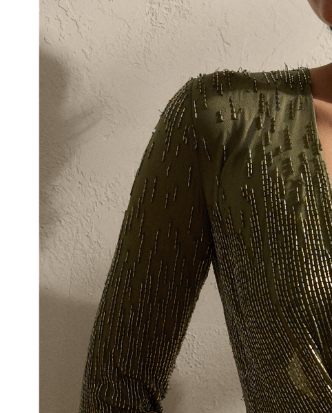 Showcasing Mr Lauren's commitment to fine craftsmanship, the Stacy's body-skimming column silhouette is meticulously hand-embroidered by a team of seven master artisans. Using a traditional Aari technique, glass bugle beads in two distinctive shades are positioned sporadically across the bodice and down the skirt, creating a linear dégradé effect. This romantic evening style features a dramatic plunging neckline framed by delicate ruching.