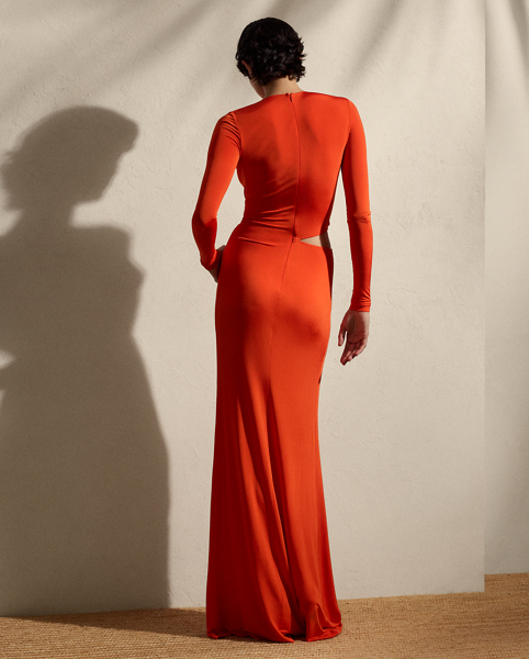 This glamorous evening gown is carefully crafted in Italy with a shiny viscose blend selected for its excellent drape and sheen. Distinguished by the season’s vibrant orange hue, this long-sleeve dress is detailed with a twist-front accent and a subtle cutout on the waist, creating a style that embodies understated elegance.