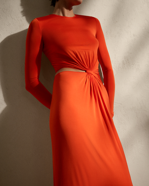 This glamorous evening gown is carefully crafted in Italy with a shiny viscose blend selected for its excellent drape and sheen. Distinguished by the season’s vibrant orange hue, this long-sleeve dress is detailed with a twist-front accent and a subtle cutout on the waist, creating a style that embodies understated elegance.