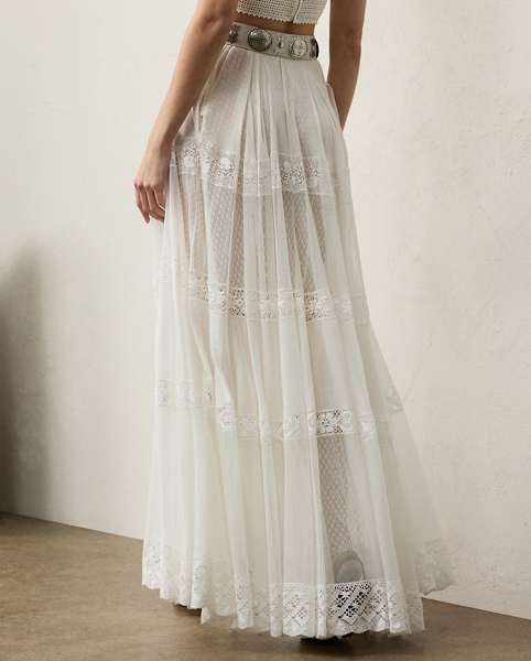 Striking a balance between elegance and rusticity, the Malti skirt's maxi-length silhouette is constructed with a series of panels and luxurious layers. A mesh lace fabric serves as the under layer, while alternating panels of sheer cotton-and-silk voile and tulle unite with hand-embroidered lace to create the exterior fabric. Crafted in Italy, this style is equipped with side on-seam pockets and a cotton lining for opacity.