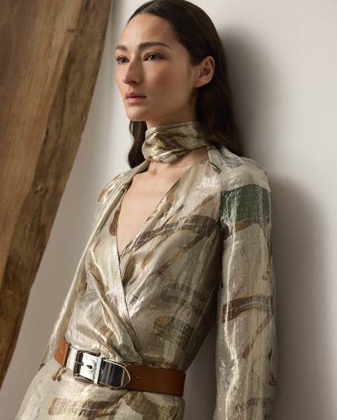 The Terry cocktail dress nods to traditional riding attire – an enduring source of inspiration for Mr Lauren since his earliest designs. Crafted from shimmering, silver-tone lamé fabric, this lean wrap dress is printed with the season's all-over equestrian-inspired motif in a renowned Italian mill in Como and designed with an array of romantic elements, including an engineered scarf, blouson sleeves and genuine mother-of-pearl buttons.