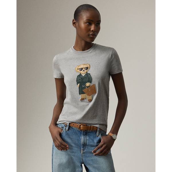 Our beloved mascot is appliquéd on this tee dressed in an outfit informed by the understated elegance that defines Pre-Autumn 2025 Collection. A team of six master embroiderers created the season's Racing Green Trench Polo Bear with highly considered materials, including synthetic leather for the bear's shoes, Ralph Lauren Tote and trench coat – whose colour is directly inspired by one of Mr Lauren's iconic vehicles – wool trench for the trousers, rib-knit cotton for the roll neck and metallic thread for the diamond earrings. This T-shirt is crafted with cotton jersey and finished with " Ralph Lauren Lauren" script embroidery.